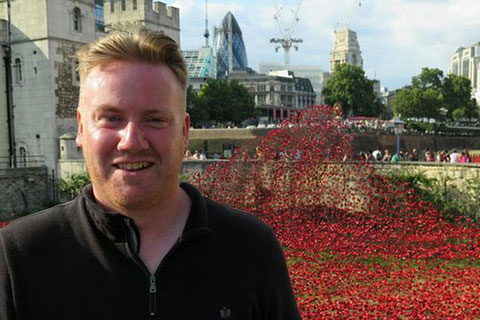 Paul Cummins standing in front of the Blood Swept Lands and Seas of Red installation at the Tower of London